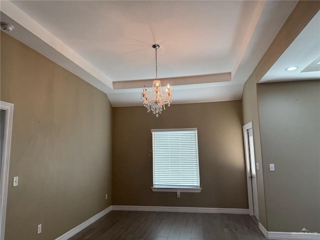 2315 N Ruby Dr, Edinburg, TX 78541 - spare room featuring a raised ceiling, a chandelier, wood finished floors, and baseboards