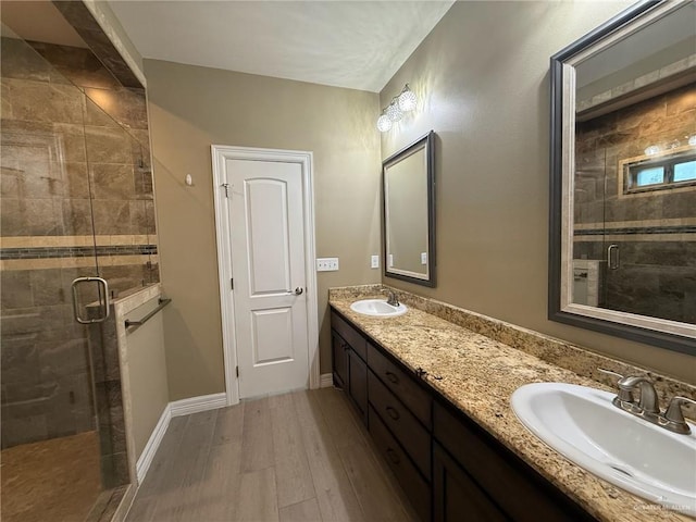 2315 N Ruby Dr, Edinburg, TX 78541 - bathroom featuring double vanity, a stall shower, wood finished floors, and baseboards