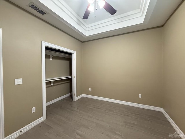 2315 N Ruby Dr, Edinburg, TX 78541 - unfurnished bedroom with a tray ceiling, wood finished floors, a closet, baseboards, and ceiling fan
