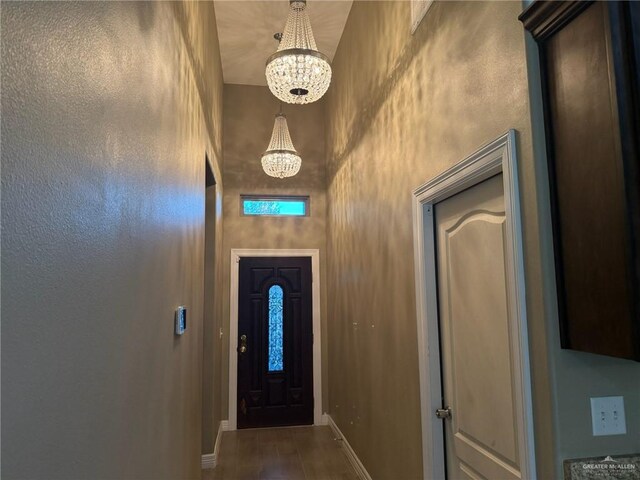 2315 N Ruby Dr, Edinburg, TX 78541 - doorway featuring a chandelier, baseboards, a towering ceiling, and wood finished floors