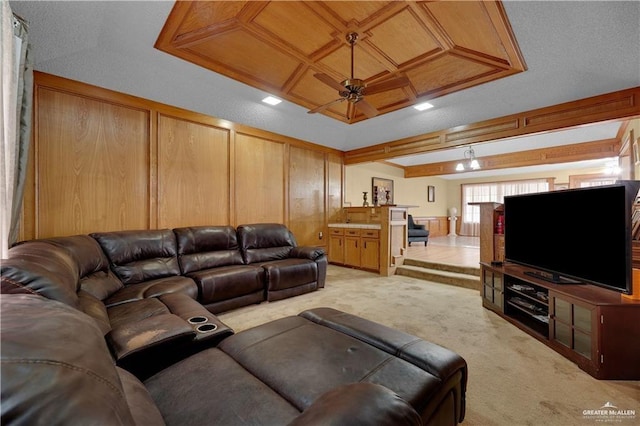 living room featuring wooden walls, light colored carpet, coffered ceiling, a ceiling fan, and beamed ceiling