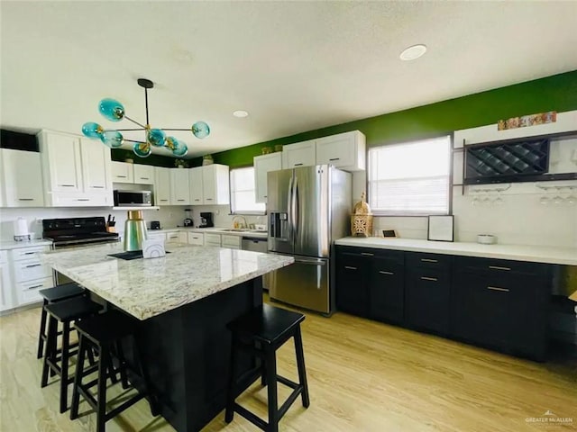 807 Walnut St, Mcallen, TX 78501 - kitchen featuring stainless steel appliances, dark cabinetry, a breakfast bar area, and white cabinetry