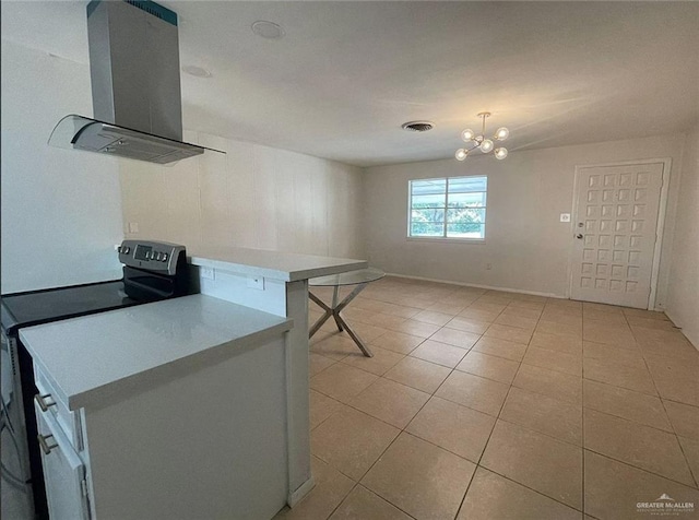 807 Walnut St, Mcallen, TX 78501 - kitchen featuring island exhaust hood, stainless steel range with electric stovetop, light tile patterned floors, light countertops, and a chandelier