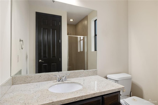 bathroom featuring vanity, an enclosed shower, and toilet