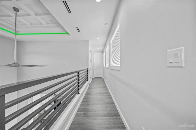 hall with dark wood-type flooring and coffered ceiling