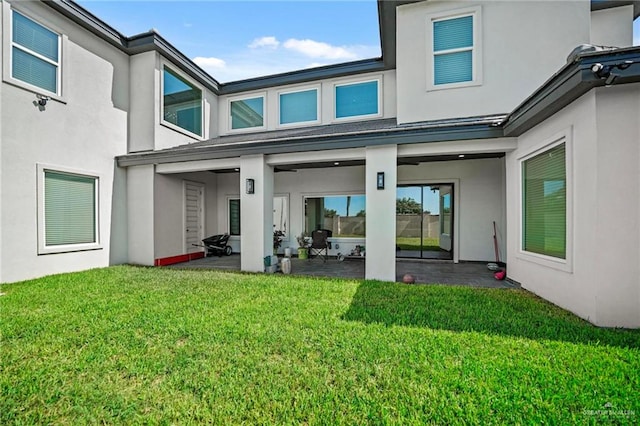 back of property featuring a lawn and a patio