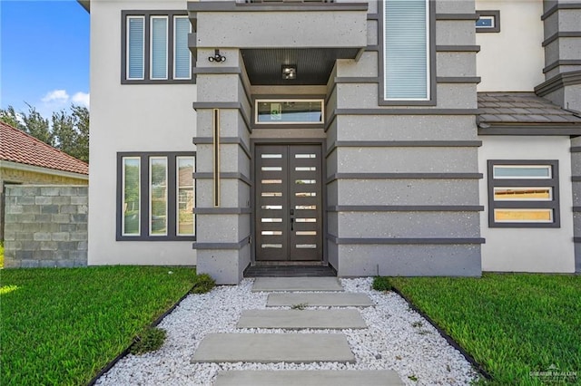 entrance to property featuring a yard and a balcony