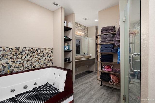 bathroom featuring hardwood / wood-style floors and plus walk in shower