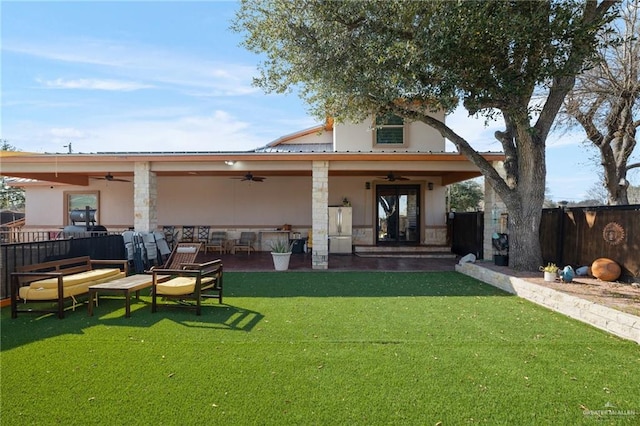 back of house featuring ceiling fan and a lawn