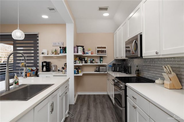 kitchen featuring sink, appliances with stainless steel finishes, decorative backsplash, white cabinets, and decorative light fixtures