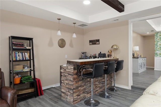 bar with beam ceiling, decorative light fixtures, and dark hardwood / wood-style floors