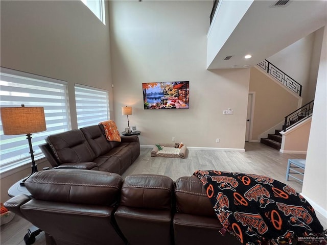 living room with a high ceiling and light wood-type flooring