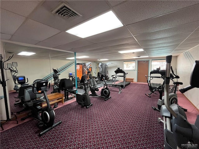 workout area featuring carpet and a paneled ceiling