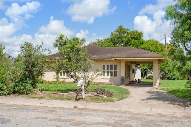 view of front of house with a front lawn and a carport