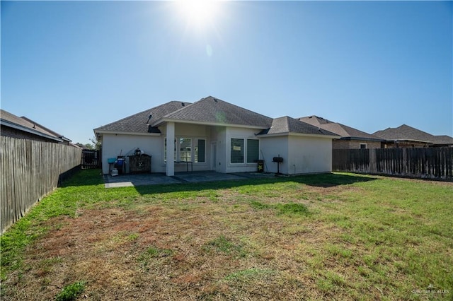 rear view of house with a patio area and a lawn