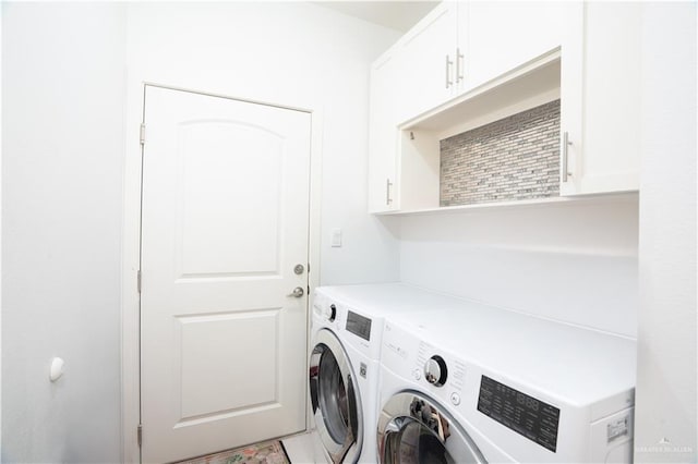 washroom with cabinets and washing machine and dryer