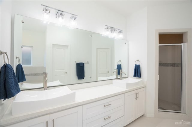 bathroom featuring tile patterned flooring, vanity, and walk in shower