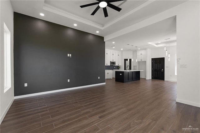 4722 Browne, Brownsville, TX 78520 - unfurnished living room featuring a tray ceiling, a ceiling fan, a sink, dark wood finished floors, and recessed lighting