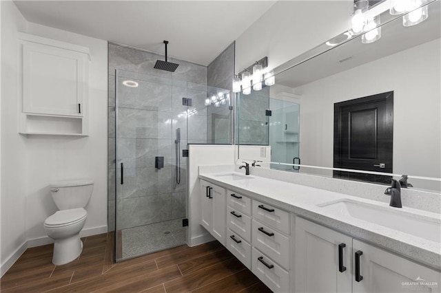 4722 Browne, Brownsville, TX 78520 - full bathroom featuring double vanity, a shower stall, wood finished floors, toilet, and baseboards