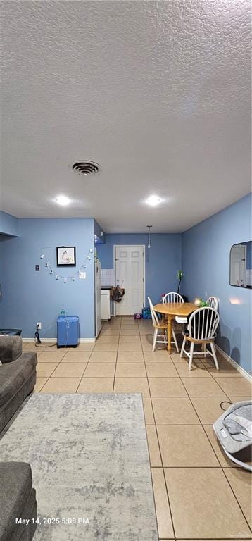 1009 W Champion St, Edinburg, TX 78539 - dining area with light tile patterned floors, a textured ceiling, and baseboards