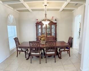 dining room with tile patterned flooring, beam ceiling, and coffered ceiling