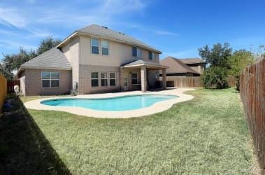 view of swimming pool with a yard