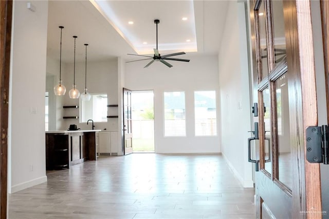 1904 Trophy Dr, Edinburg, TX 78542 - unfurnished living room featuring a tray ceiling, recessed lighting, baseboards, ceiling fan, and a sink