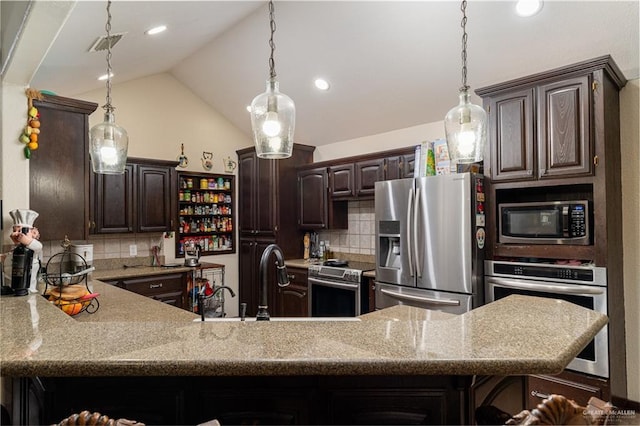 kitchen with hanging light fixtures, vaulted ceiling, stainless steel appliances, and dark brown cabinets