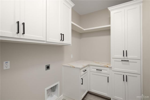 clothes washing area with hookup for an electric dryer and cabinet space