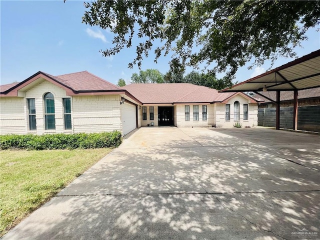 view of front facade with a carport, a garage, and a front yard