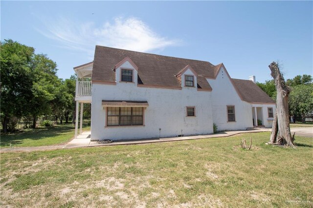 11009 Monte Cristo Rd, Edcouch, TX 78538 - view of front of property with a front yard, a balcony, and stucco siding
