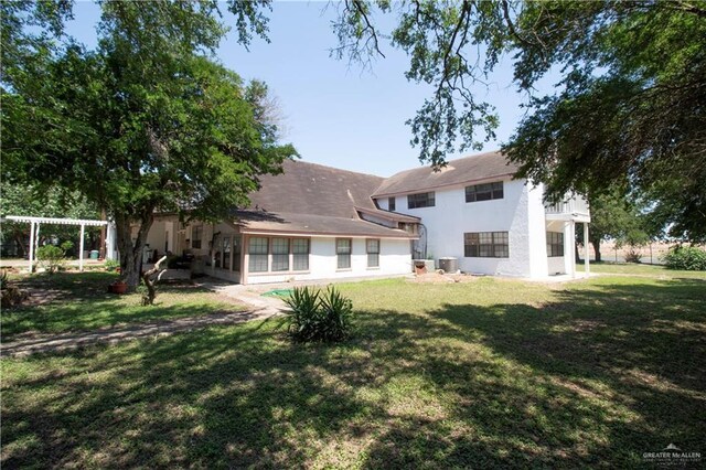11009 Monte Cristo Rd, Edcouch, TX 78538 - rear view of house with stucco siding, a yard, and a pergola