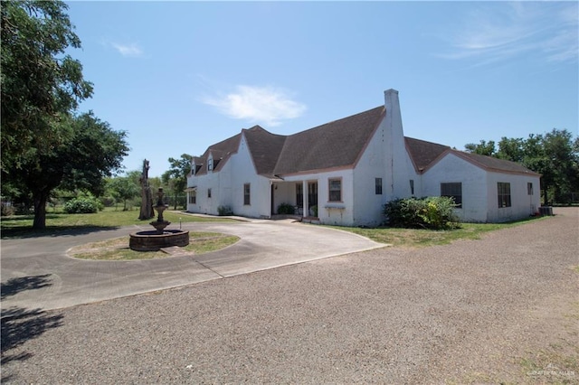 11009 Monte Cristo Rd, Edcouch, TX 78538 - view of front of home with curved driveway, a chimney, and stucco siding