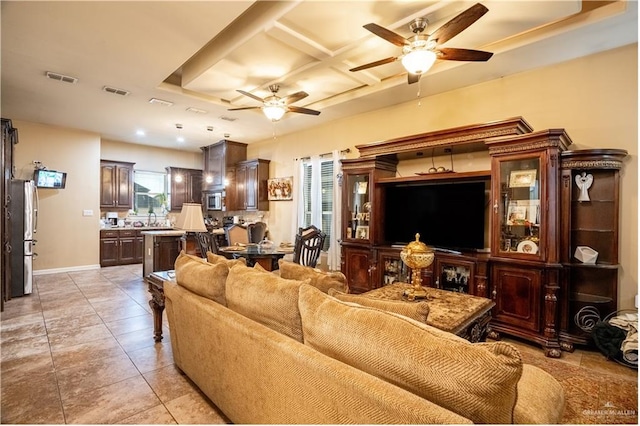 living room with ceiling fan, sink, light tile patterned floors, and coffered ceiling