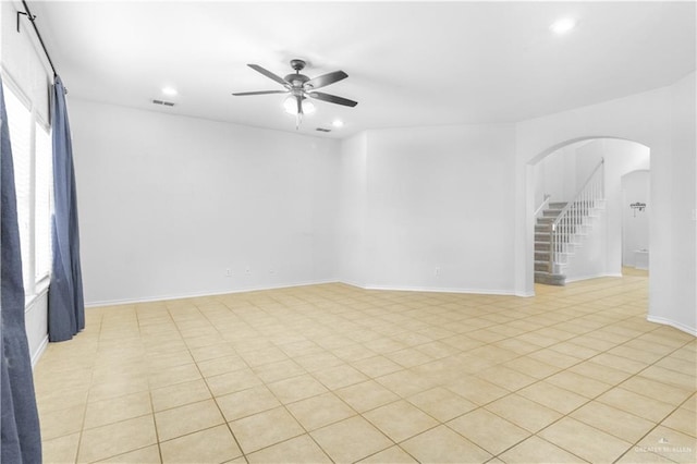 tiled spare room featuring ceiling fan