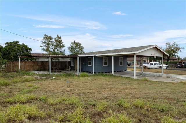 ranch-style house featuring a carport and a front yard