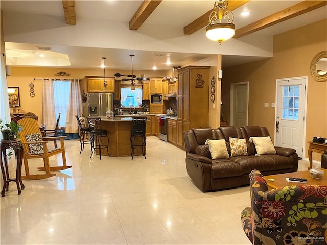 living room with beam ceiling, light tile patterned floors, and a wealth of natural light