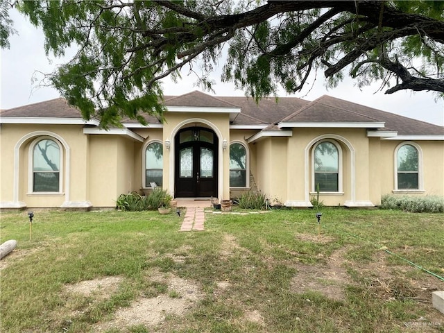 single story home with french doors and a front yard