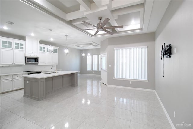 kitchen featuring a kitchen island with sink, white cabinets, ceiling fan with notable chandelier, decorative light fixtures, and stainless steel appliances