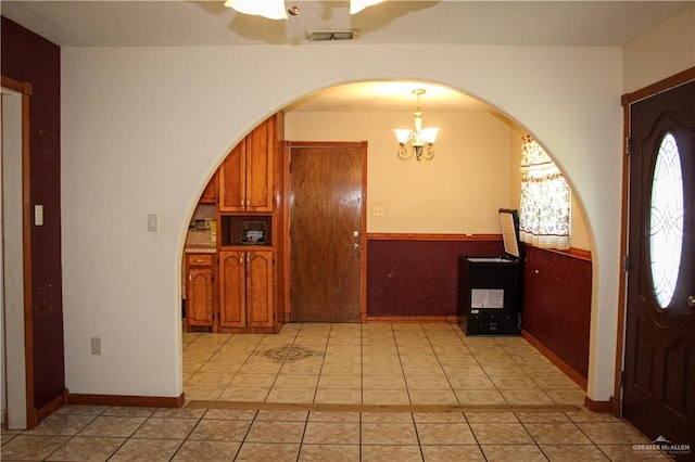 kitchen featuring pendant lighting, light tile patterned floors, and a chandelier