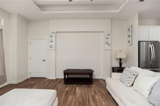 living room featuring dark hardwood / wood-style floors and a tray ceiling