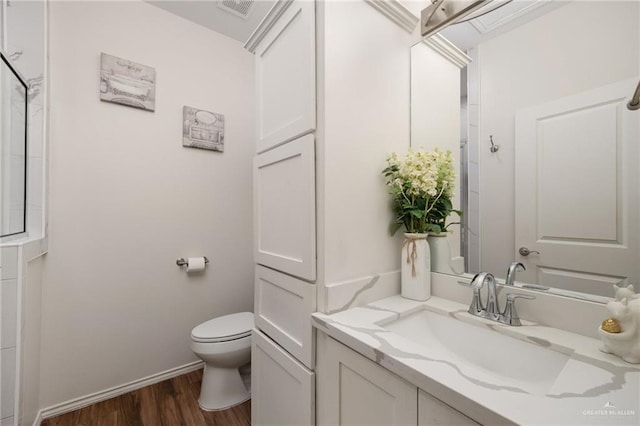 bathroom featuring wood-type flooring, vanity, and toilet