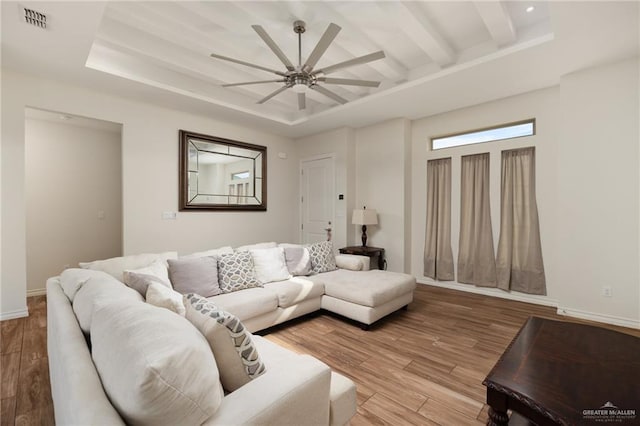 living room featuring ceiling fan, beamed ceiling, and light wood-type flooring