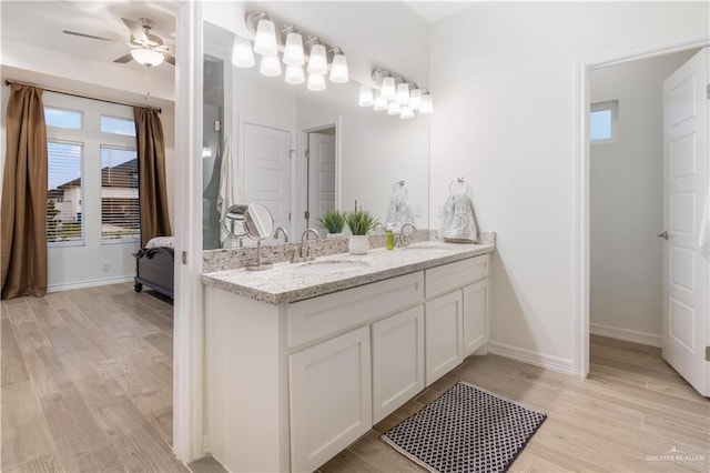 2104 Macquarie Dr, Edinburg, TX 78542 - ensuite bathroom featuring healthy amount of natural light, double vanity, a ceiling fan, and wood finished floors