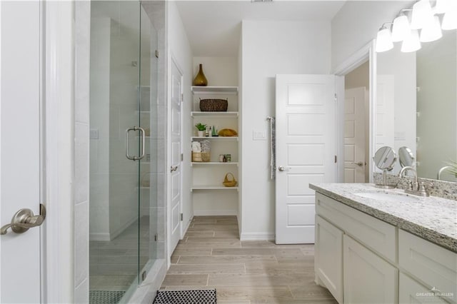 2104 Macquarie Dr, Edinburg, TX 78542 - bathroom featuring a shower stall, wood finish floors, vanity, and baseboards