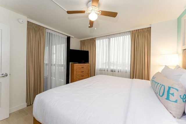 bedroom with multiple windows, ceiling fan, and light hardwood / wood-style flooring