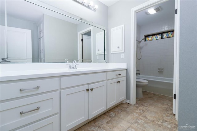 full bathroom with toilet, vanity, and tiled shower / bath