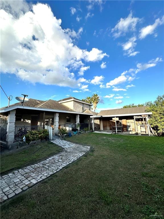 rear view of house featuring a lawn