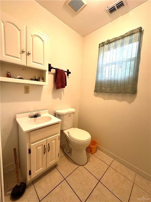 bathroom with tile patterned flooring, vanity, and toilet