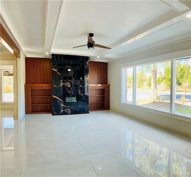 unfurnished living room with wood walls, an accent wall, a ceiling fan, and beamed ceiling